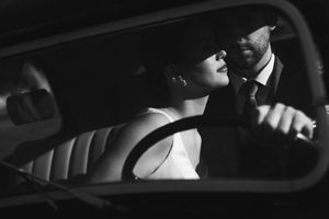 Romantic black and white photo of a couple in a vintage car interior. Next day wedding photography.