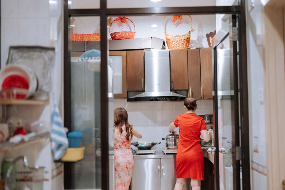 View through doorway of kitchen interior with people in red attire.
