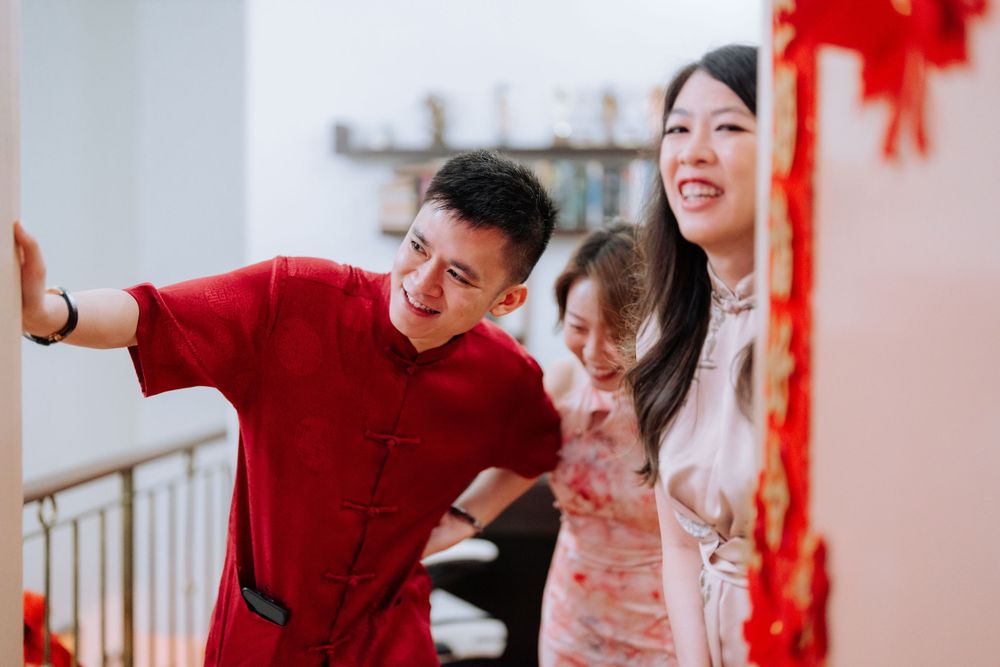 Family members sharing laughter during Chinese New Year celebrations in festive red clothing.