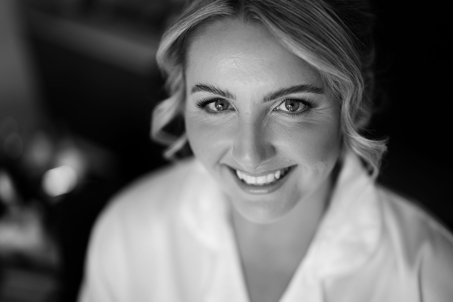 Black and white close-up portrait showing joyful expressions at a wedding celebration.