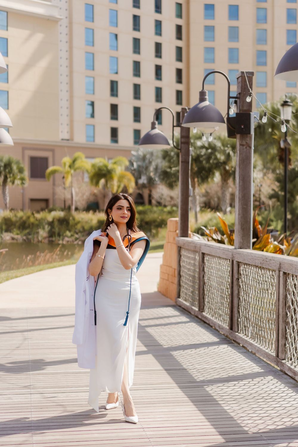 A series of photos showing someone in a white dress posing on a walkway with palm trees and buildings in the background.