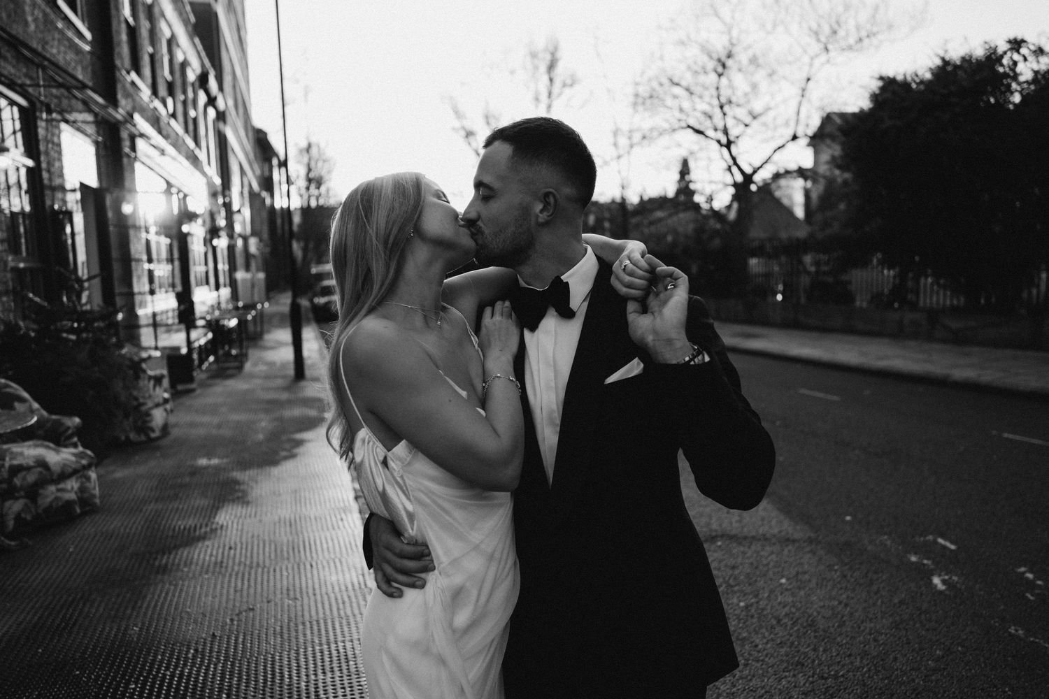 Black and white candid photos of couple kissing outside bourne and hollingsworth