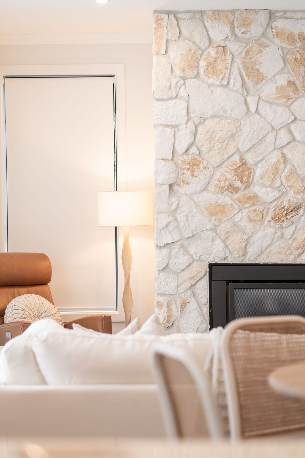 Modern living room interior with white stone wall, brown furniture and soft natural lighting creates a cozy atmosphere.