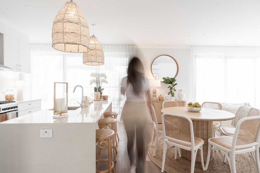 Bright and airy modern dining space with woven pendant lights and white furniture in a minimalist setting.