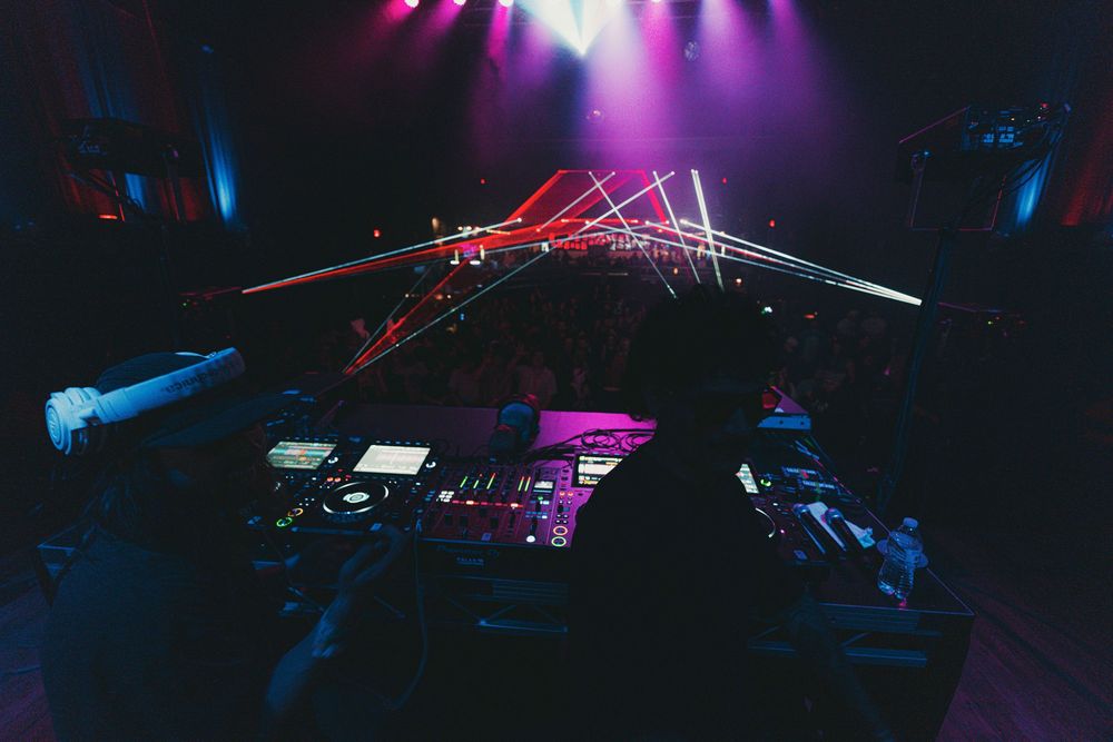Concert stage illuminated with vibrant purple and blue lighting effects during a live music performance.