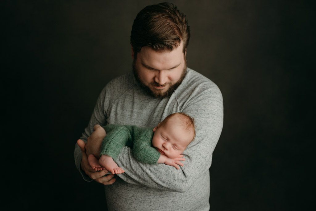 A series of tender moments photography showing a parent cradling and bonding with their newborn baby at the studio in victoria bc.