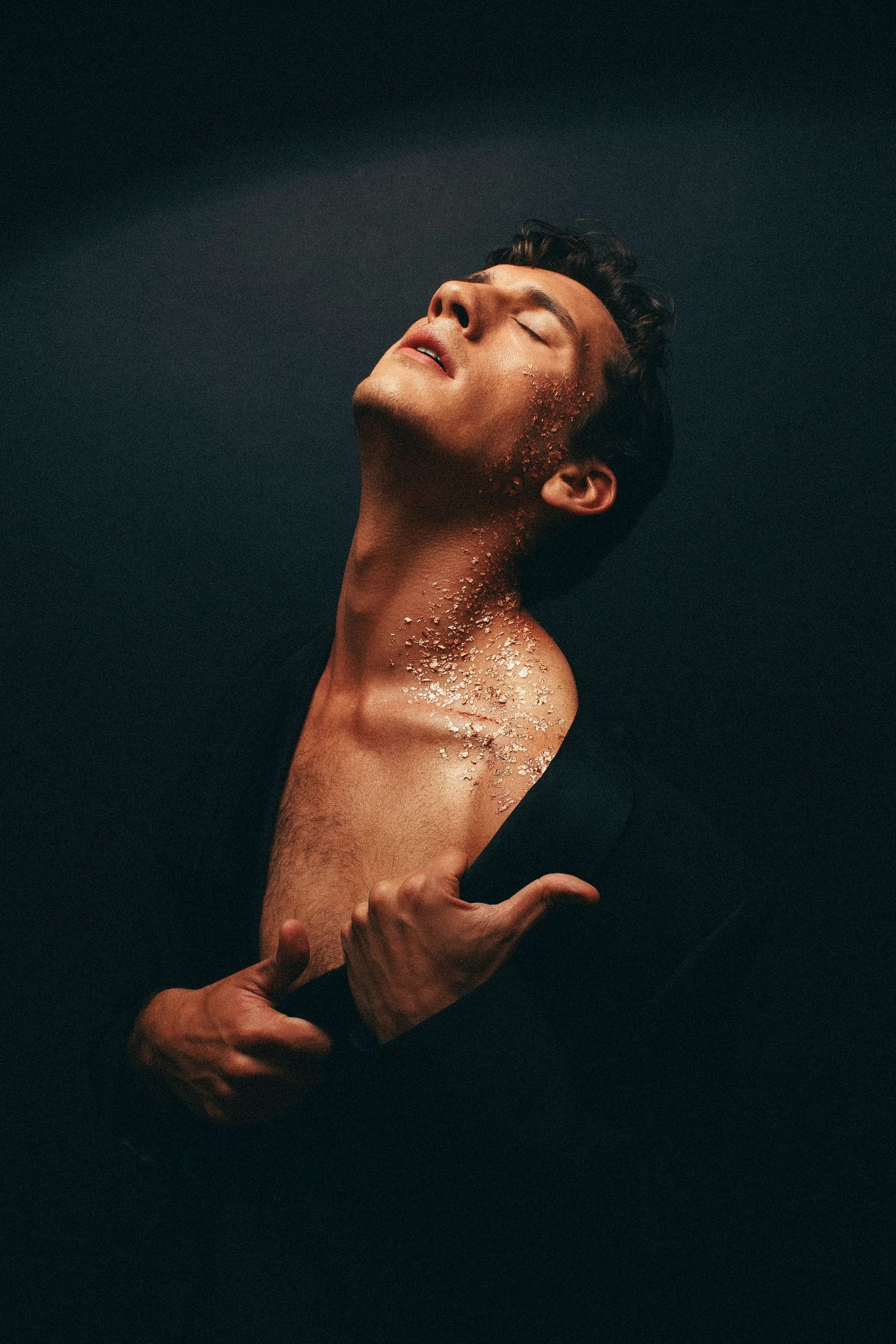 Moody and sensual photoshoot. SOft sheen to the models skin and gold leaf, peeling effect.