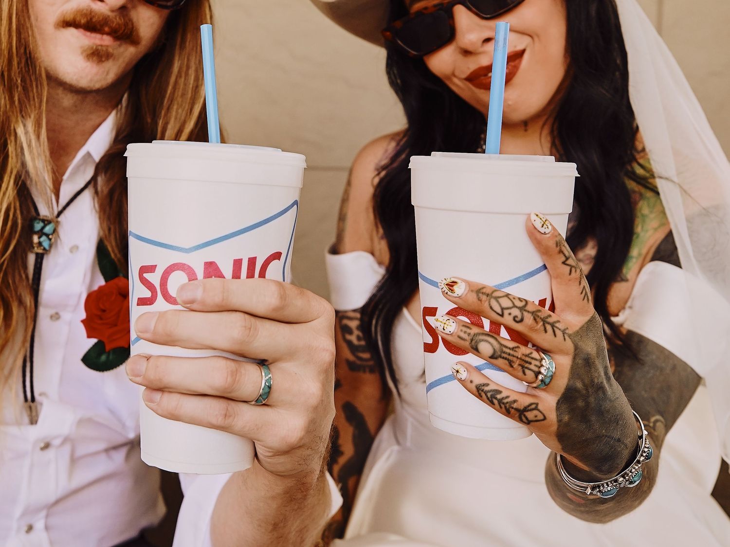 Close-up of hands holding Sonic drinks and food items during an editorial photoshoot