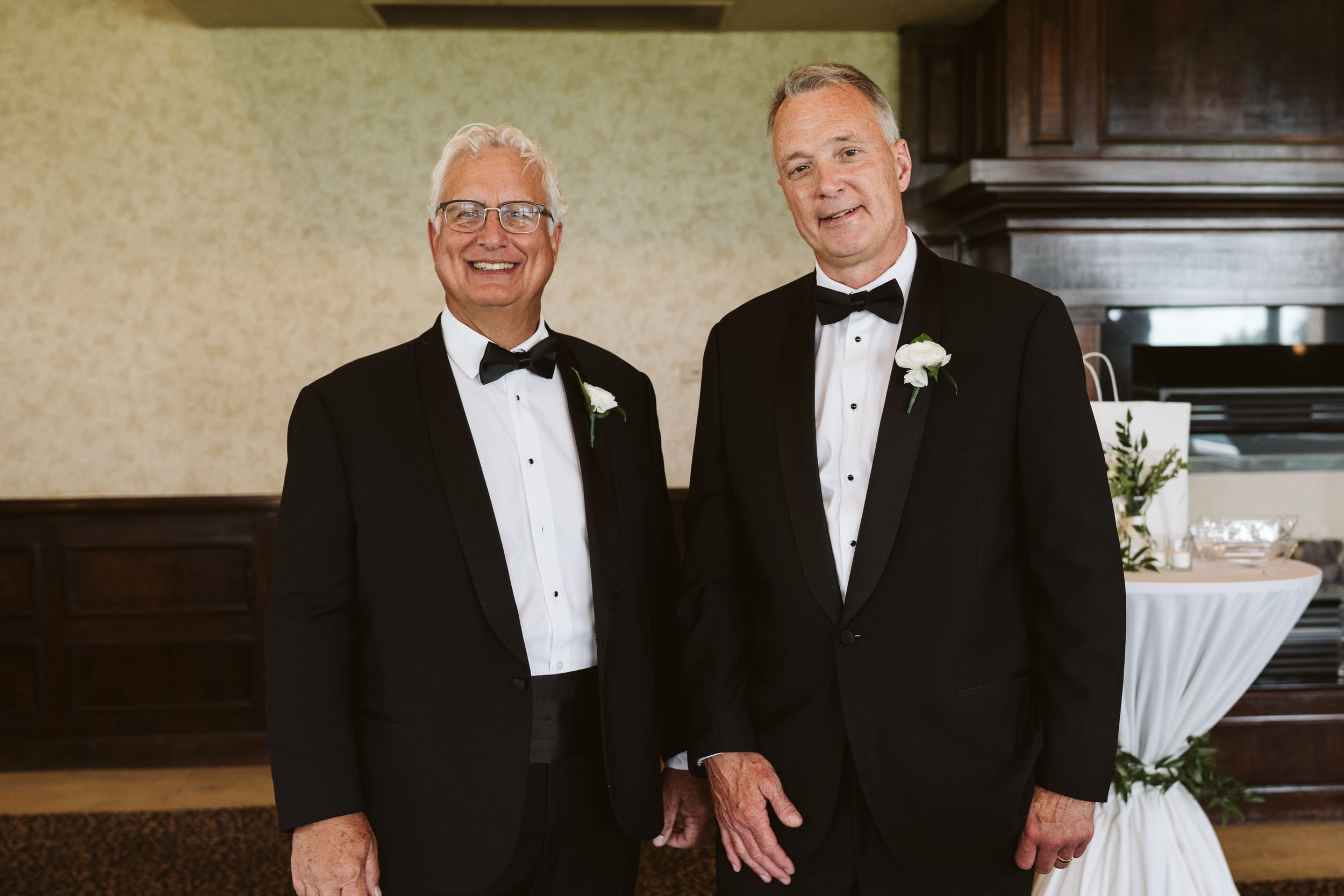 Wedding guests in formal black tuxedos gathered for a celebratory photo.