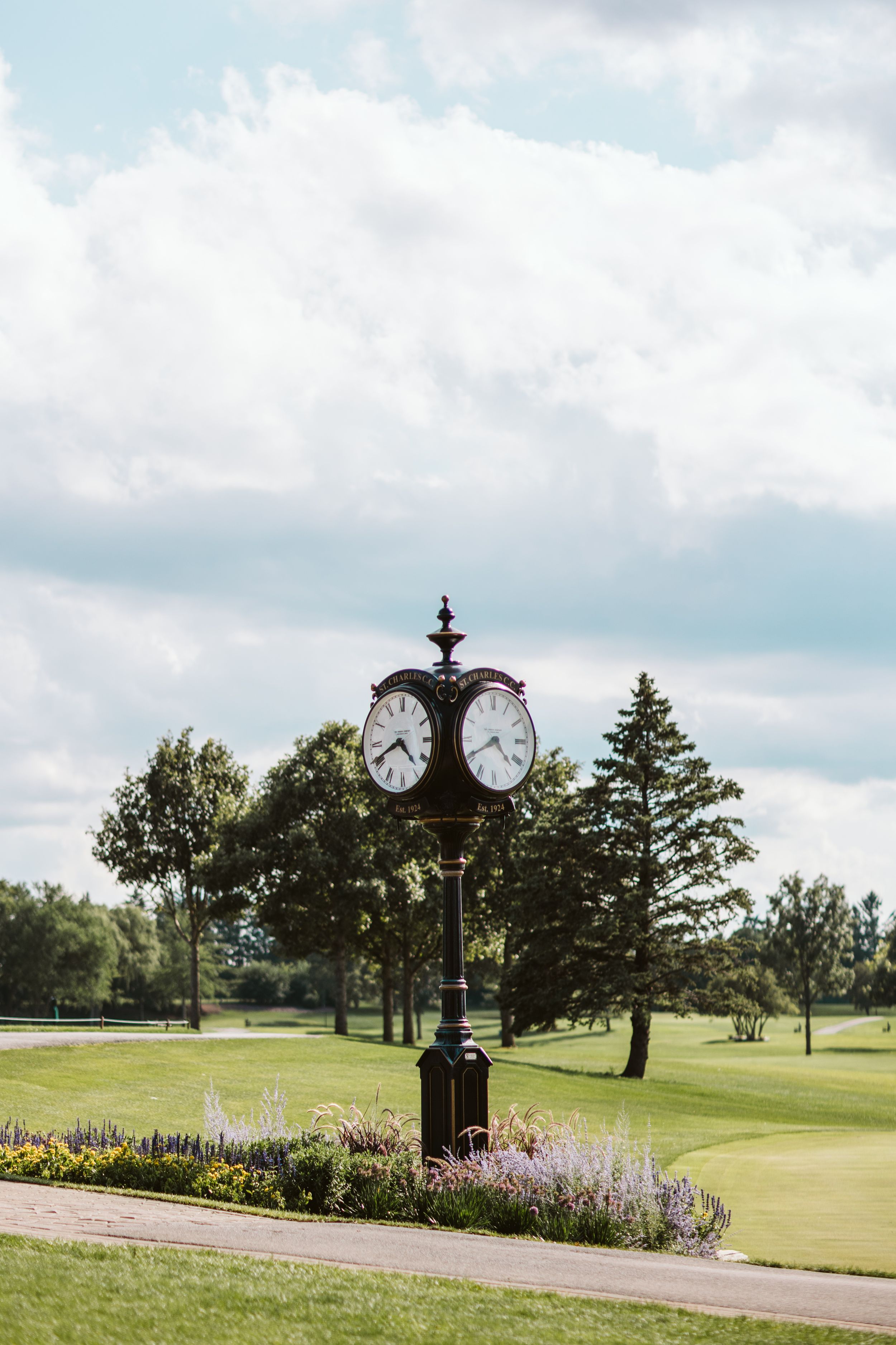 Beautiful golf course landscape with ornate clock tower and colorful flower gardens.
