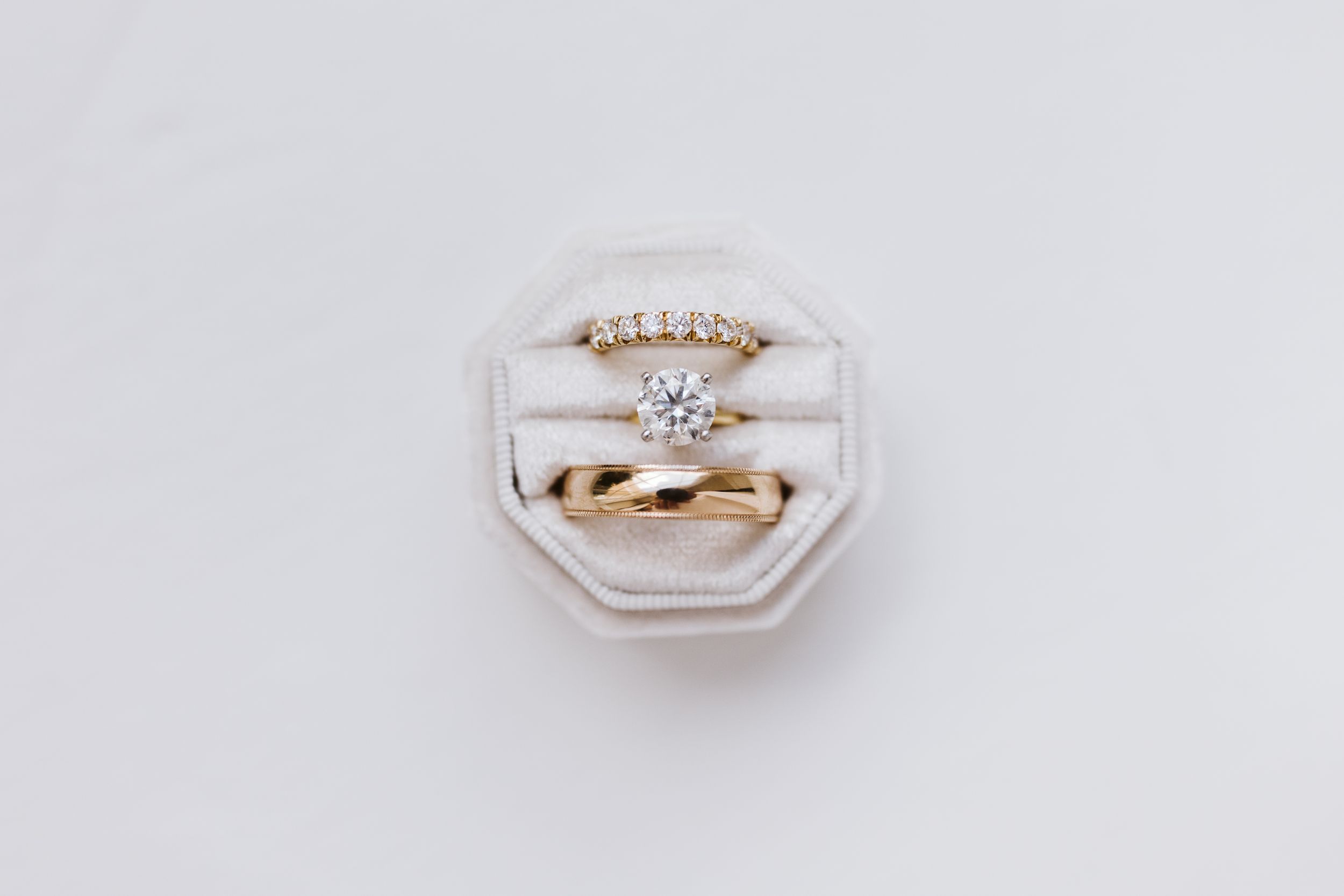 Close-up view of an elegant diamond engagement ring on a white surface.