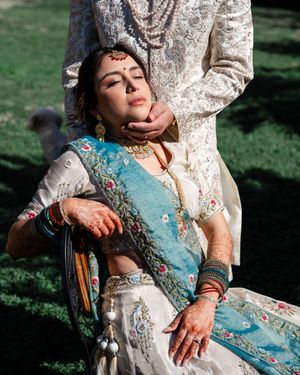 A sequence of artistic shots showing someone in a turquoise and white embellished dress reclining against a tree outdoors.