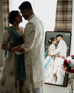 A couple in traditional wedding attire shares an intimate moment during their wedding photoshoot.