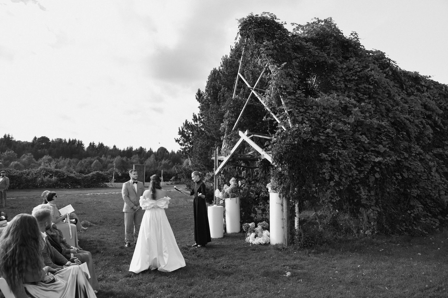 A series of black and white wedding photos showing outdoor ceremony and reception moments.