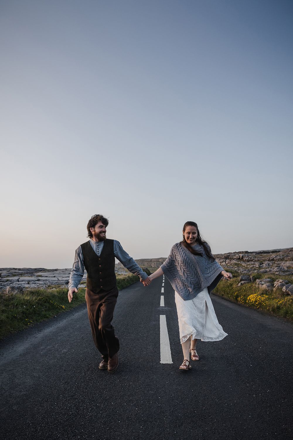 Bride and groom exploring Burren coastal landscape after eloping at Hags Head Cliffs of Moher