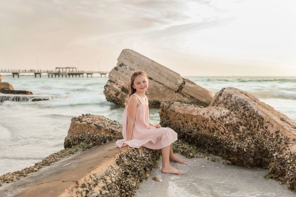 Coastal photography setup with large rocks and ocean waves during golden hour.