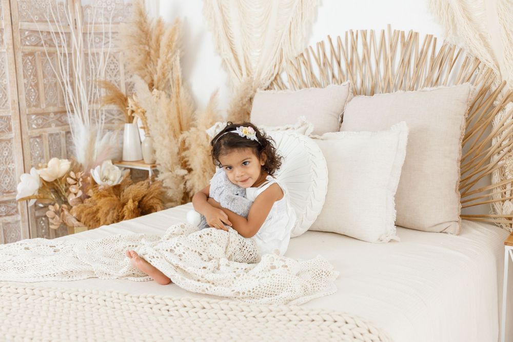 Boho inspired photo setup with neutral tones, pampas grass, and white textiles.