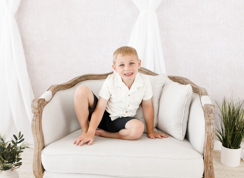 Clean white studio setup with vintage couch and minimalist decorations.
