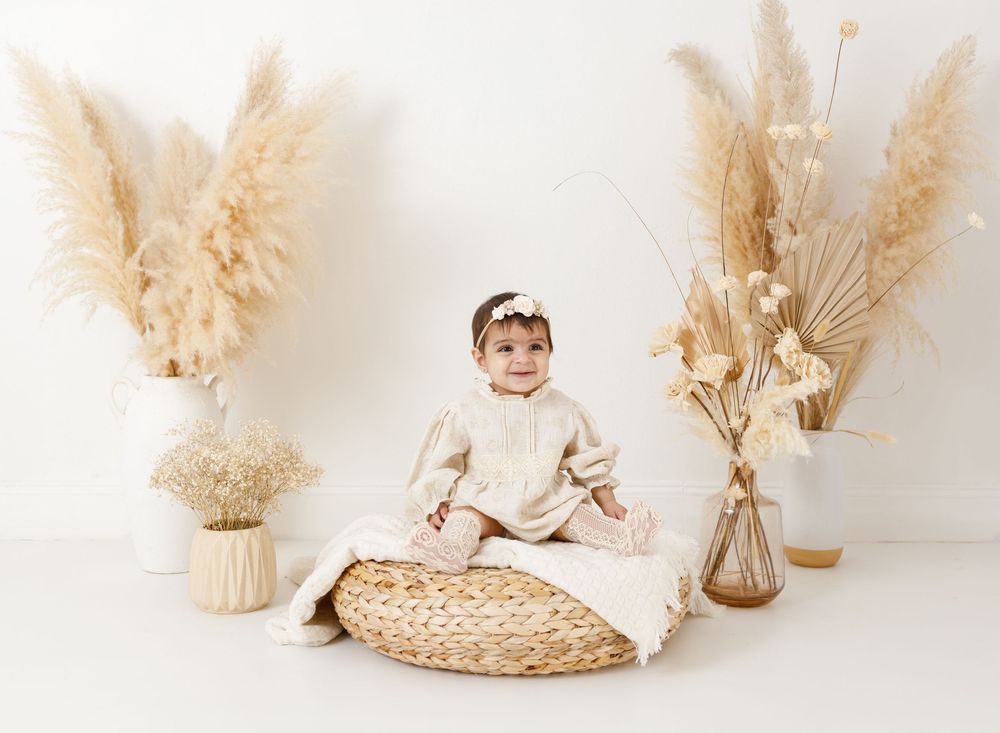 Natural boho themed photo setup with pampas grass and woven basket decorations.