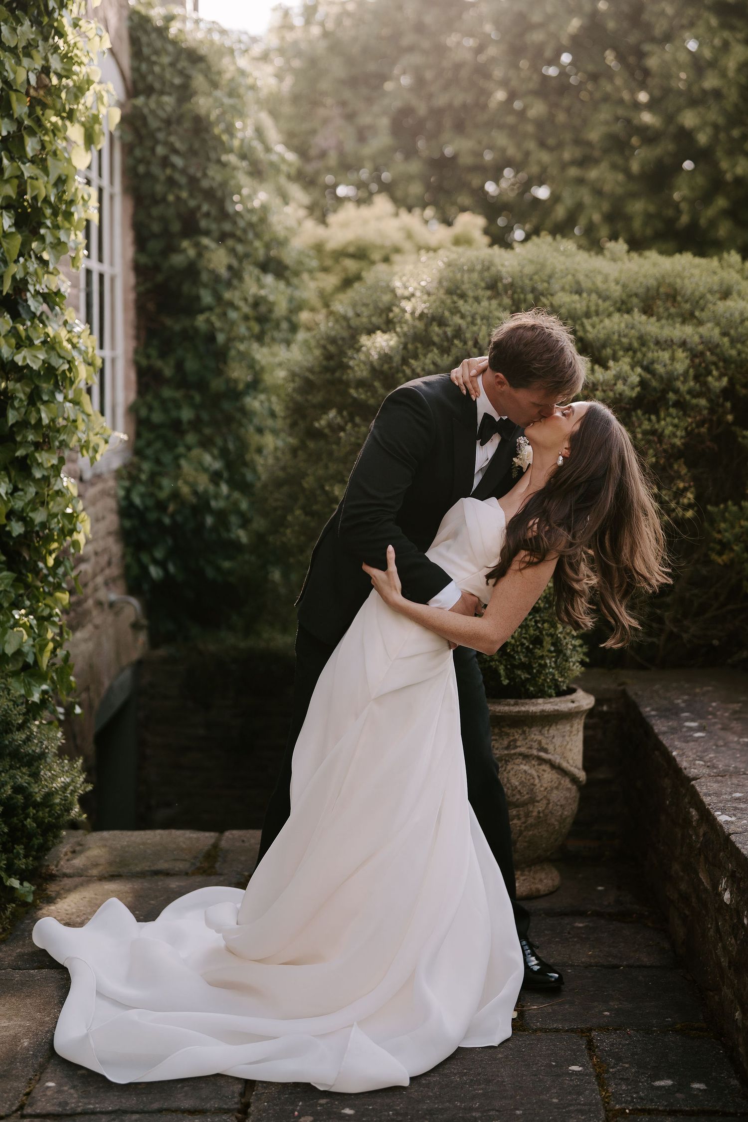 groom kissing bride as he dips her at dewsall court in herefordshire
