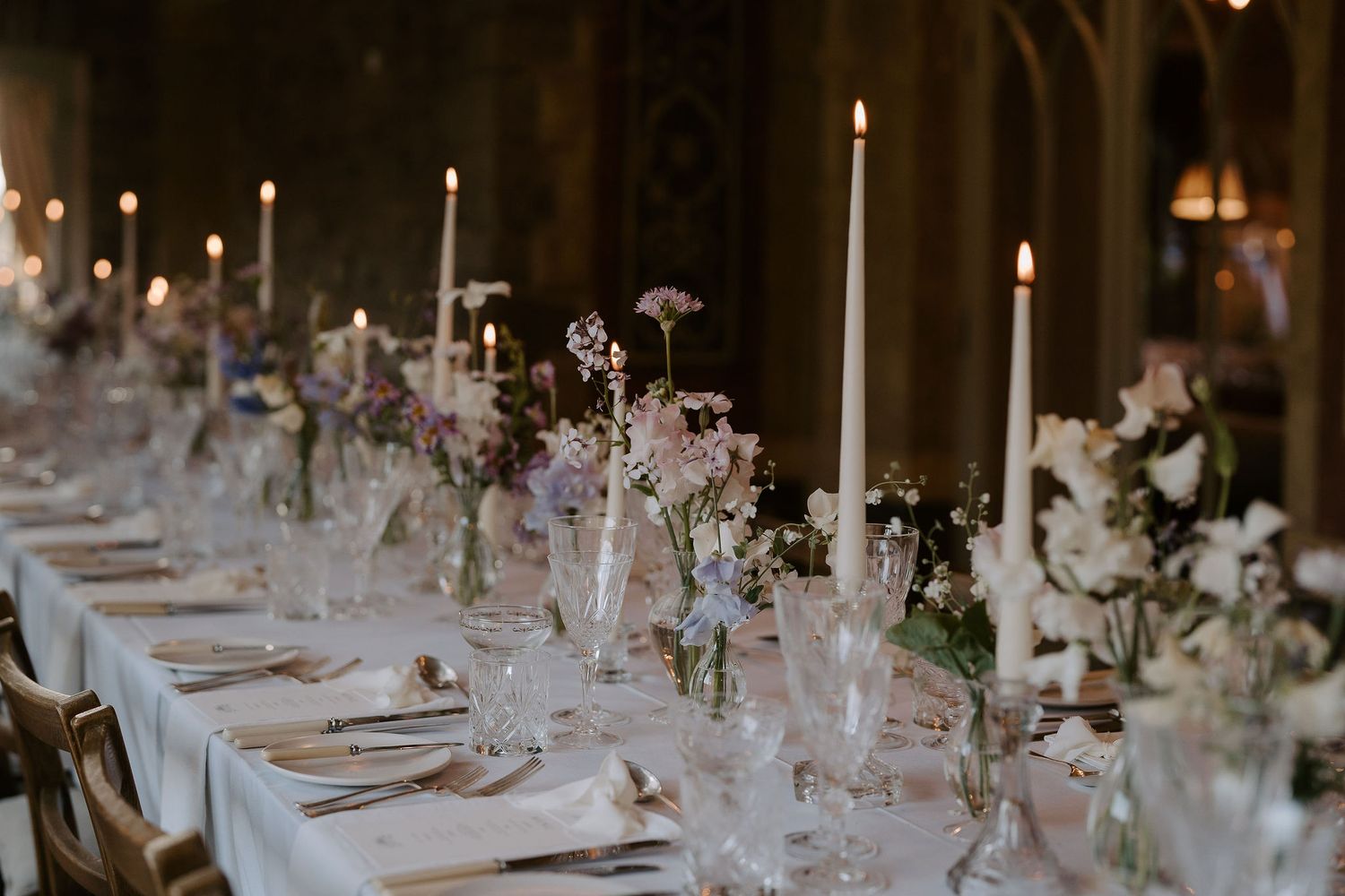 table dressed in candles and flower arrangements before meal is served at dewsall court in herefordshire