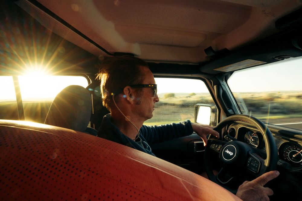 Interior view of a car dashboard illuminated by golden sunset light streaming through the windshield.