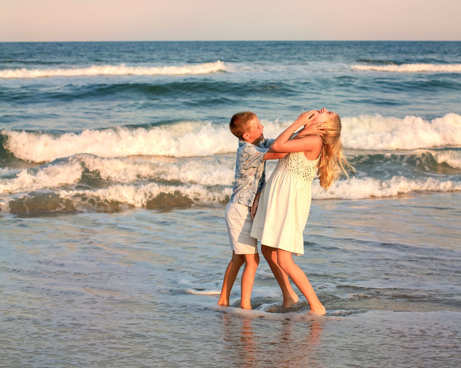 Brother and sister laughing and playing on beach in LBI, NJ