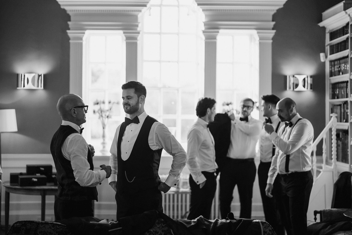 groomsmen getting ready for the wedding in the library at Iscoyd park