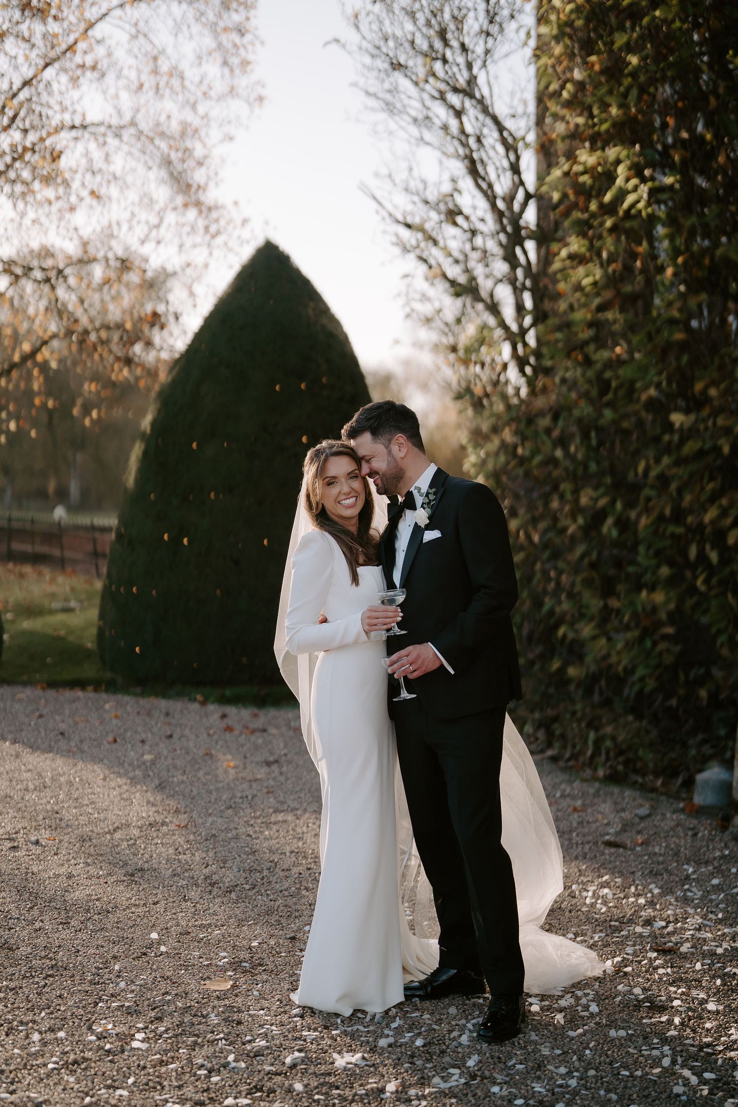 groom resting his head against the brides head as she smiles outside Iscoyd park