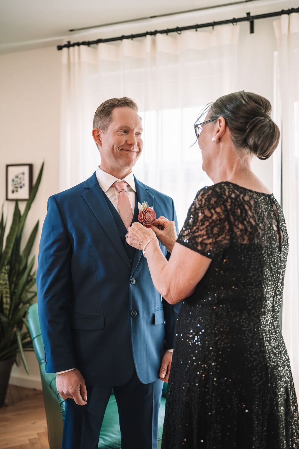 Wedding day preparation scene with formal attire and pink floral boutonniere.