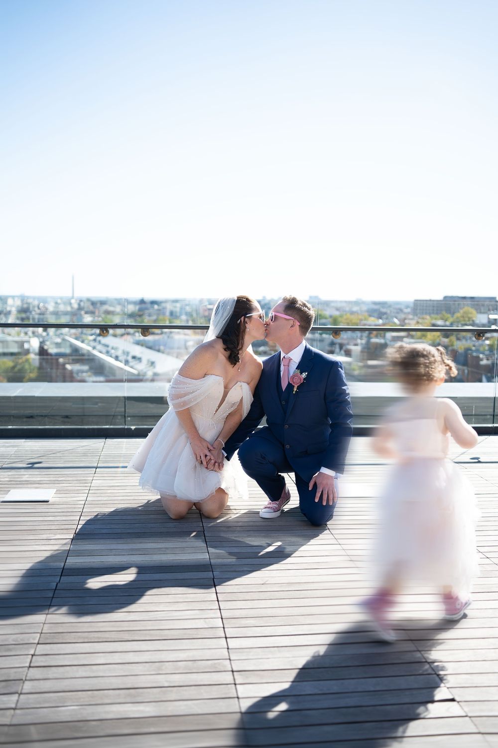 Sun-drenched rooftop photography session with couple in formal attire.