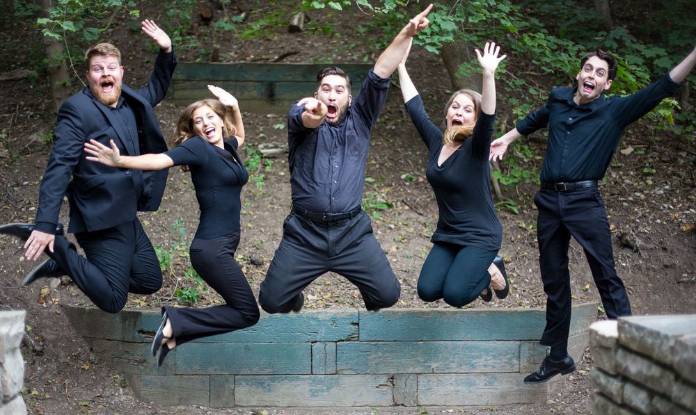 Group photo showing people jumping and posing playfully on outdoor steps.