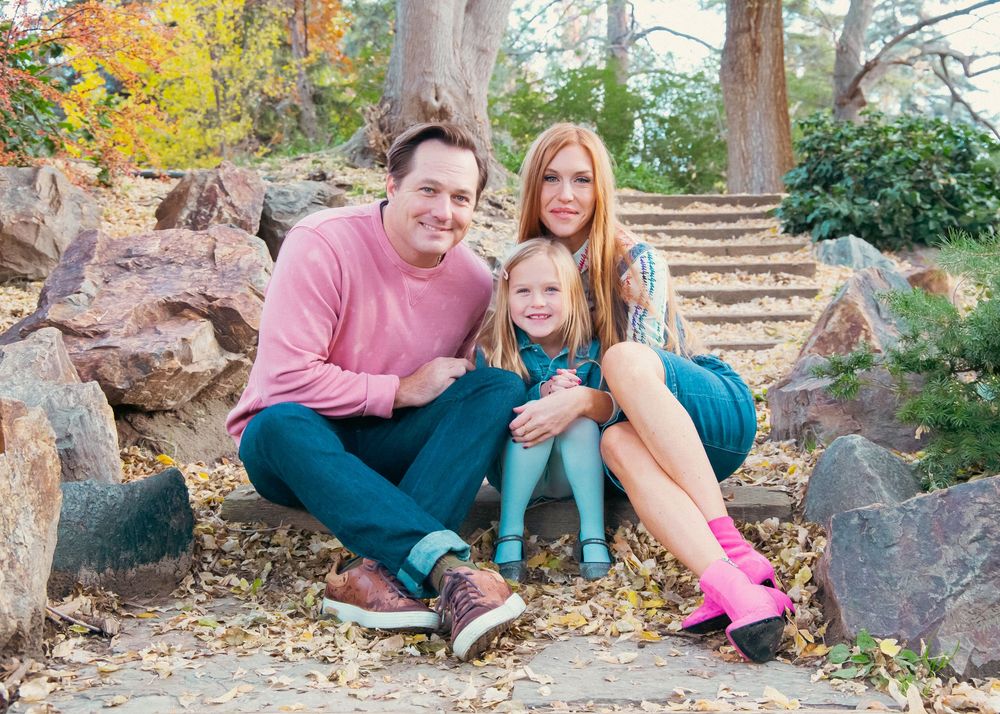 Couple relaxing on stone steps surrounded by fall foliage.
