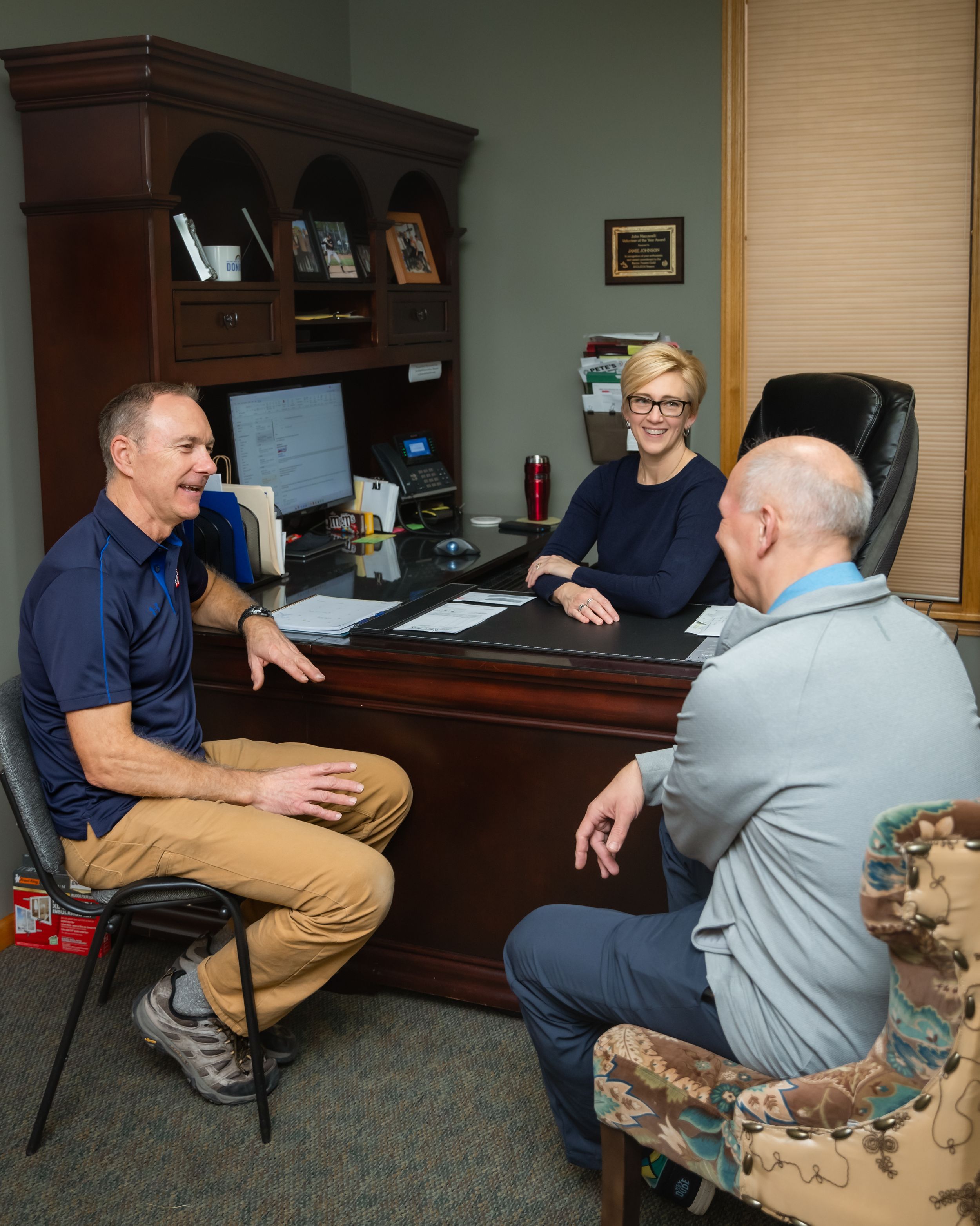 A sequence of five images showing two people in casual attire having an animated conversation in an office setting.