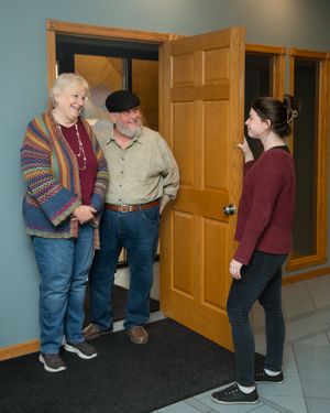 Sequence of images showing people interacting near a wooden door in a hallway.