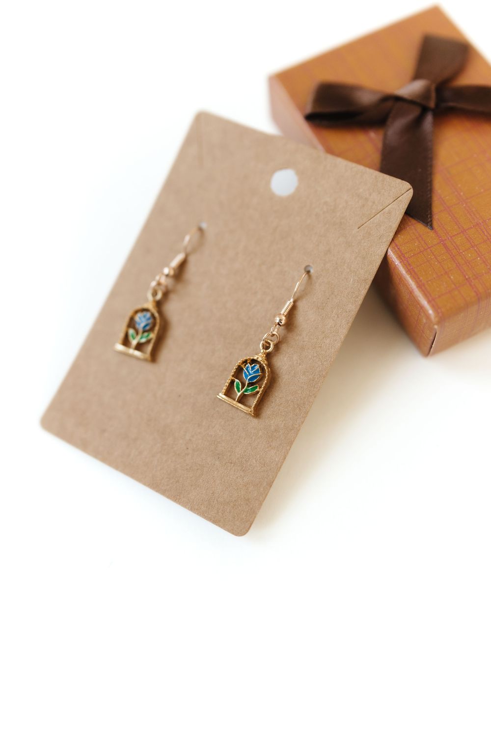 Small floral earrings displayed on kraft paper jewelry cards.