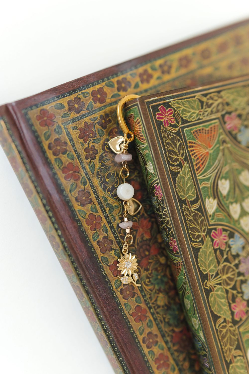 Decorative bookmark with floral patterns against vintage book pages.