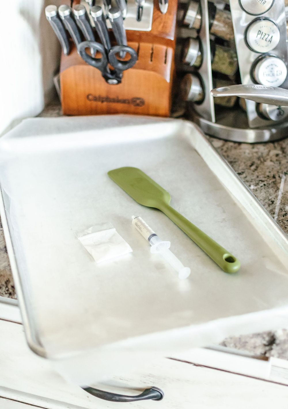 Kitchen utensils and tools laid out on a white cutting board.