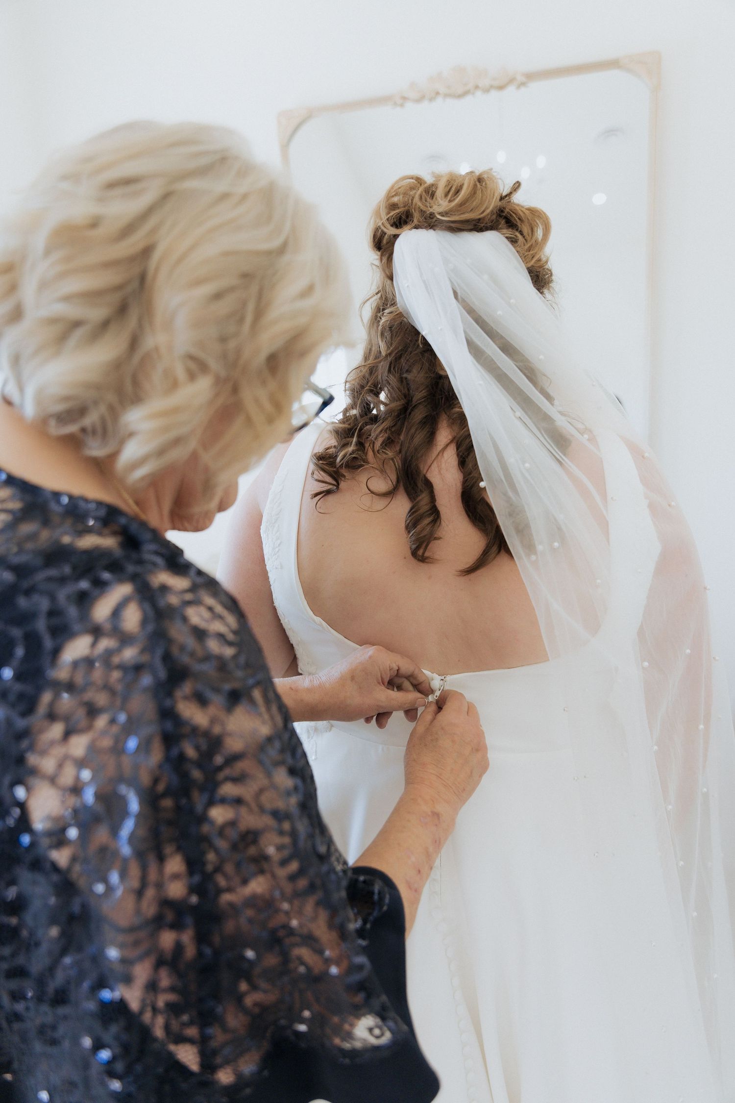 mother of the bride buttons up wedding dress at Grand Ivory wedding in Moncton, candid moment, timeless wedding photography in Moncton NB