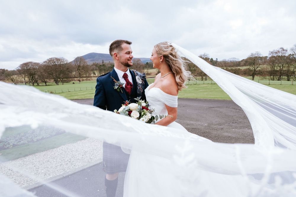 Bride and groom sharing a romantic moment on a stone path with mountains in the background.