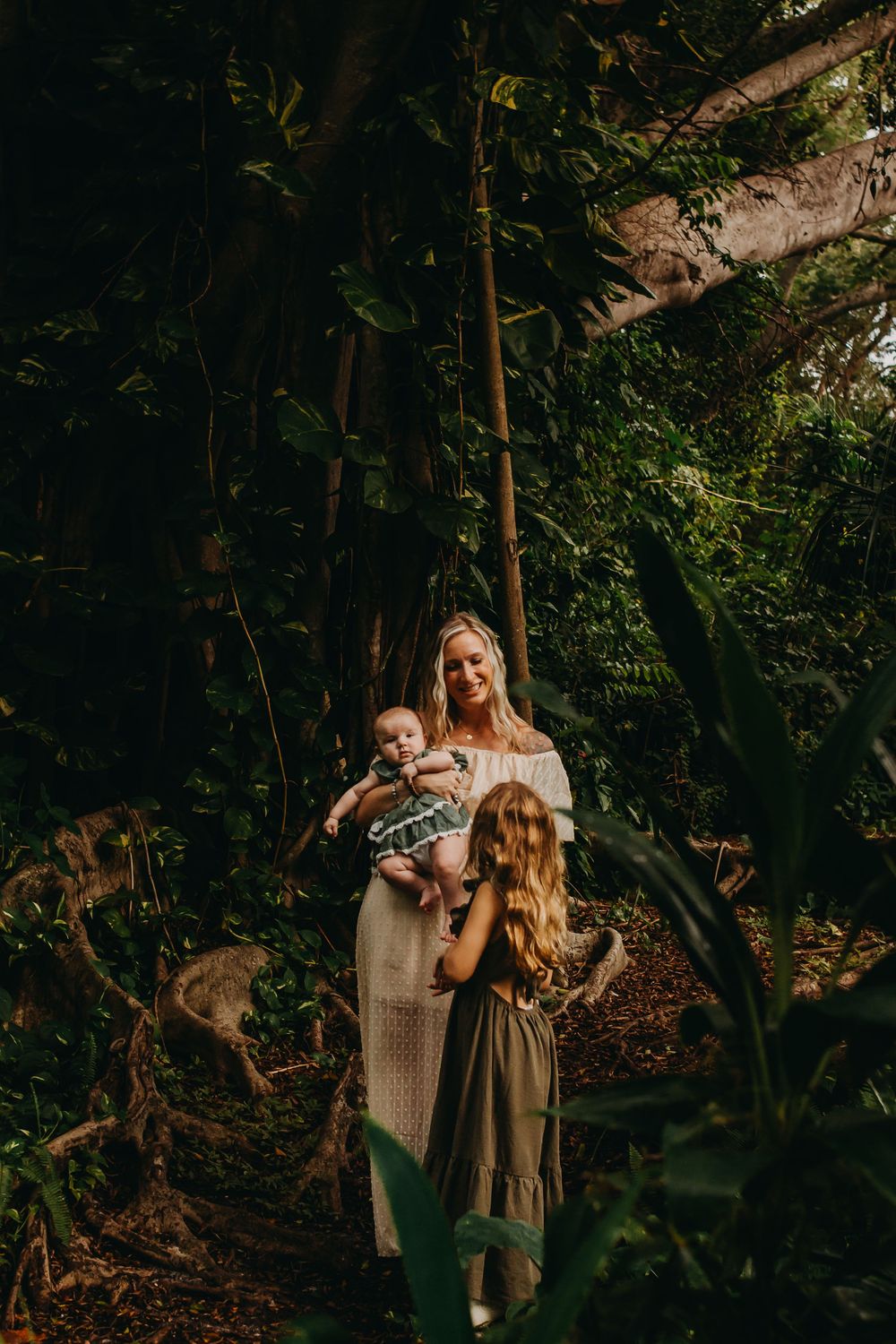 Artistic forest photoshoot showing people in earth-toned clothing amid lush greenery and natural lighting.