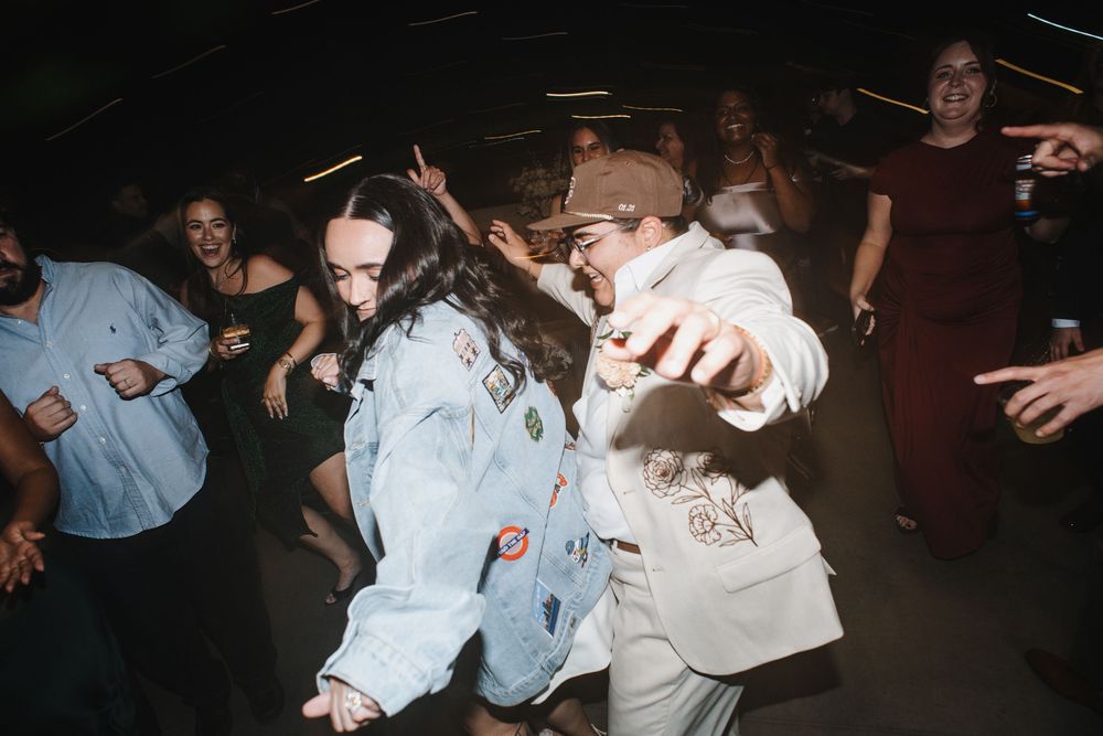 A group of people dancing and celebrating at a dimly lit party or nightclub event.