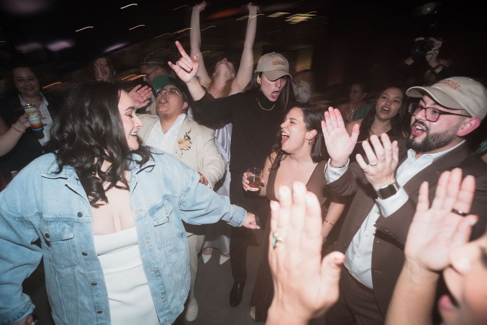 Crowd of people dancing and celebrating at a lively nightclub party event.
