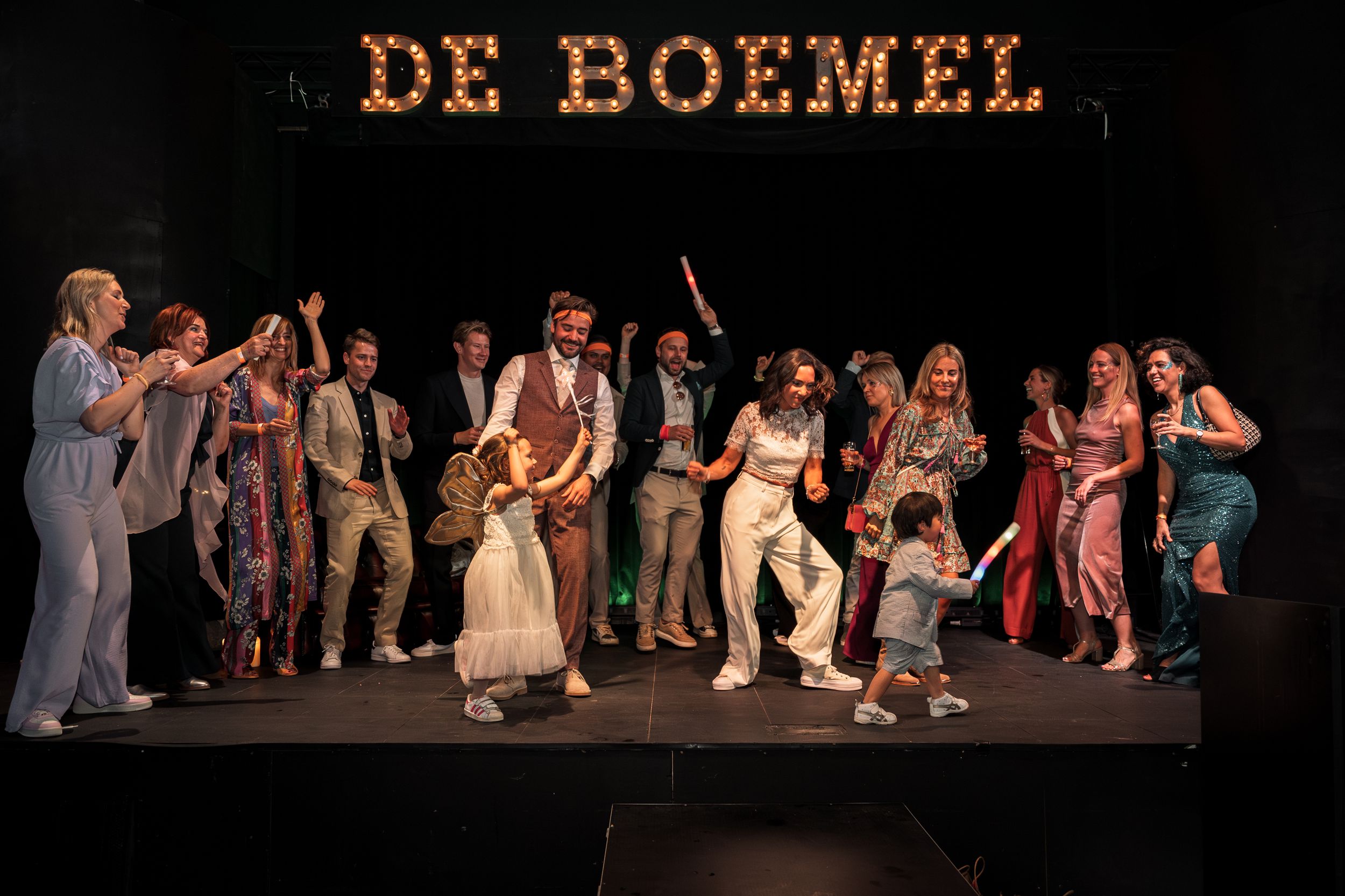 Theater performers on stage in casual vintage clothing during a scene from 'De Boemel' production.