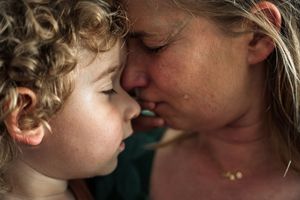 A series of tender moments between parent and child showing loving embraces and nose touches against a dark background.
