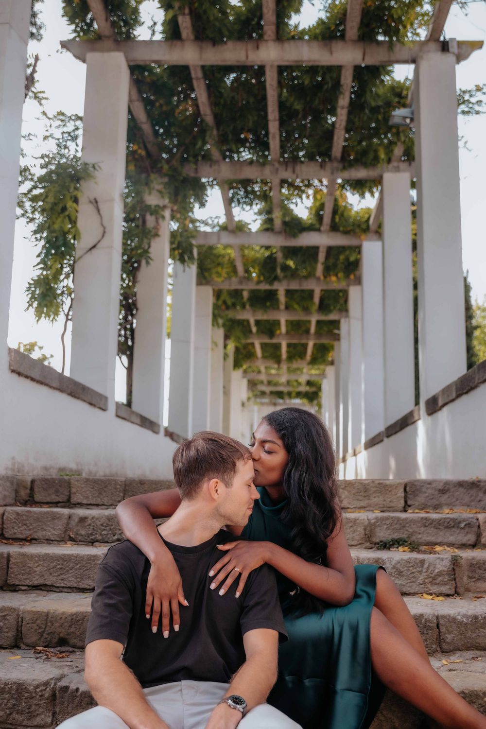 Intimate portrait of couple leaning against a tree in the gardens.