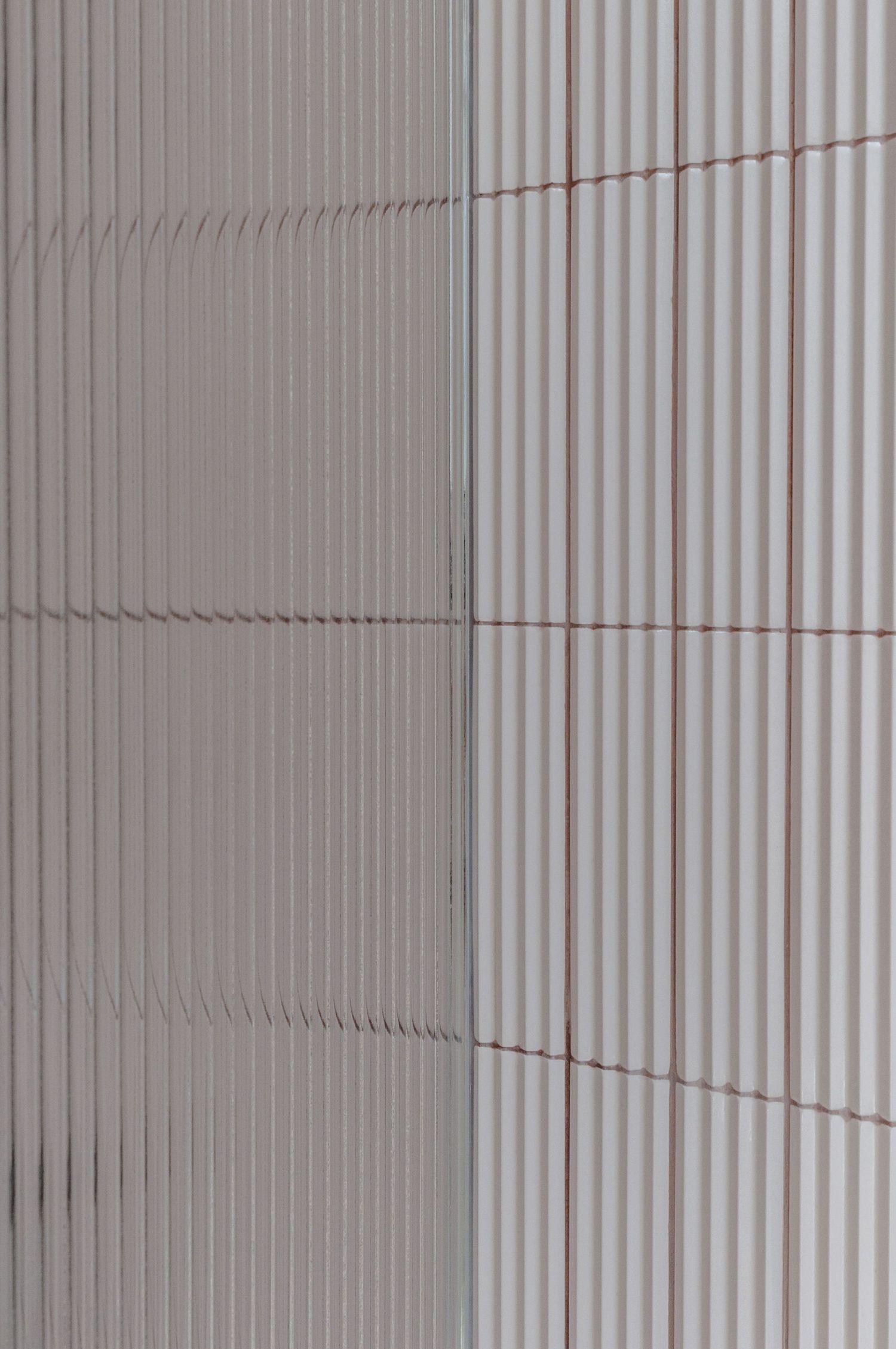 Abstract architectural detail of vertical ribbed wall panels in neutral tones.