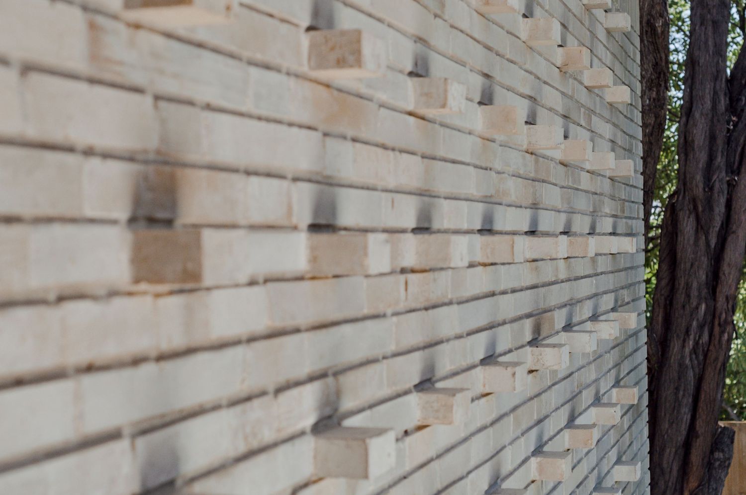 Close-up of modern architectural wall featuring linear brickwork with protruding elements.
