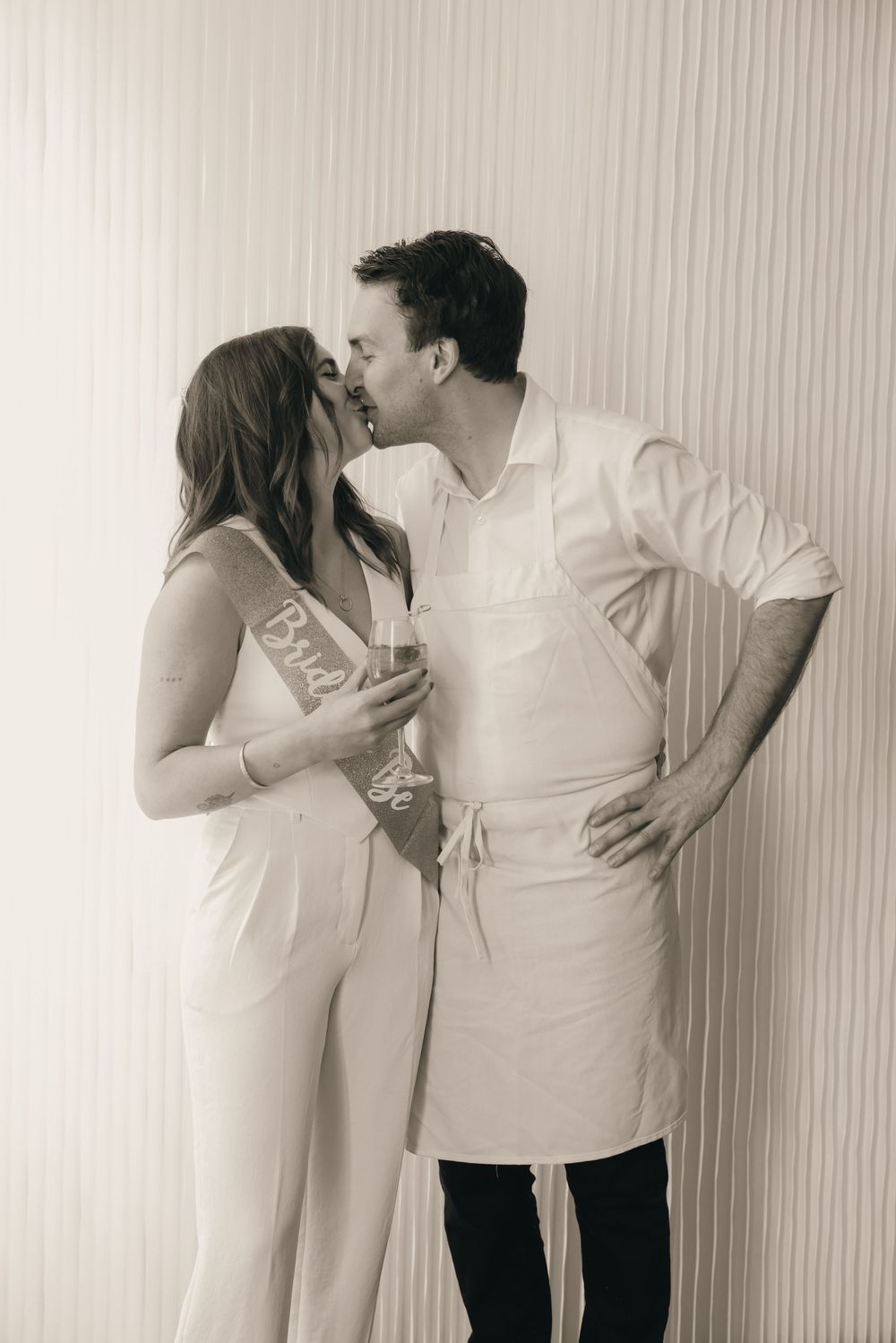 A black and white photo captures a sweet candid moment between two people.