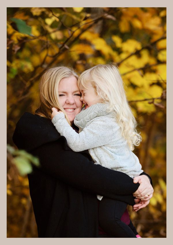 Varm kärleksfull bild av mor och dotter som kramas bland löven i höstfärger. Fotograferat på Ljunghed, Lidköping.